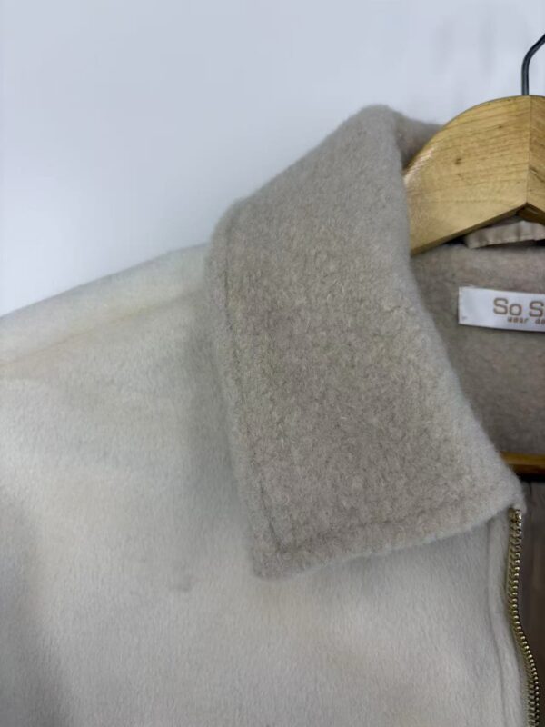 Close-up of a stylish wool coat with a beige collar and zipper, perfect for winter fashion and cold weather wear.