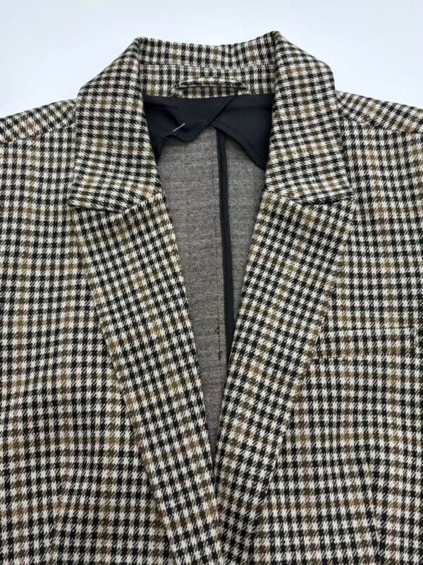 Close-up of women's houndstooth wool coat with classic collar and tailored fit, perfect for fall and winter fashion.