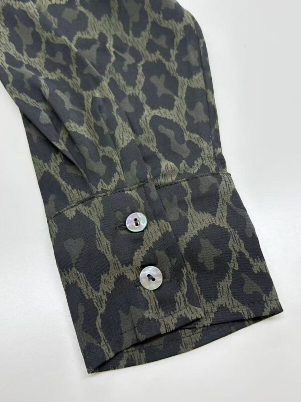 Close-up of men's dress shirt with leopard print pattern, featuring button cuffs and tailored fit, ideal for stylish formal or casual occasions.