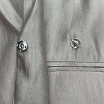 Close-up of a stylish grey blazer with silver buttons, showcasing high-quality fabric and tailored fit, perfect for formal or business occasions.