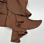Stylish brown scarf with ruffled edges, perfect for adding a touch of elegance to any outfit.