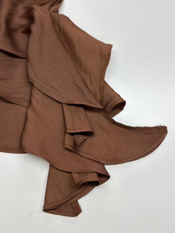 Stylish brown scarf with ruffled edges, perfect for adding a touch of elegance to any outfit.