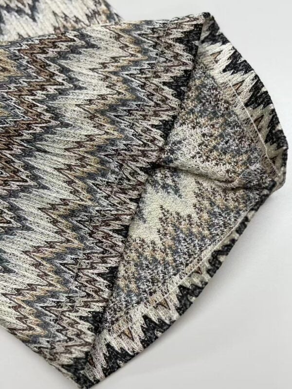 Close-up of tribal patterned fabric with intricate geometric designs in earthy tones, suitable for fashion and home decor.