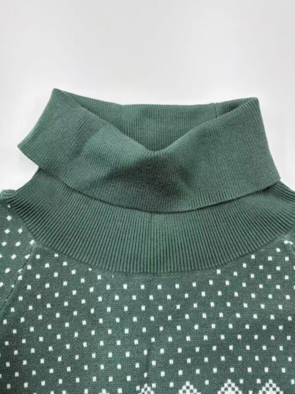 Close-up of a green turtleneck sweater with white polka dots, showcasing the ribbed collar and fabric texture.