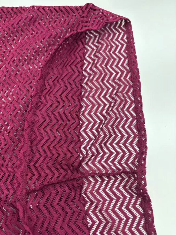 Bright pink crochet shawl with zigzag pattern, perfect for fashion and accessories, showcasing intricate craftsmanship and stylish design.
