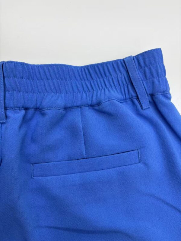 Close-up of bright blue casual pants with elastic waistband and back pocket, suitable for everyday wear and sports activities.