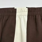 Close-up of casual brown and white jogger pants with elastic waistband, suitable for comfortable everyday wear.