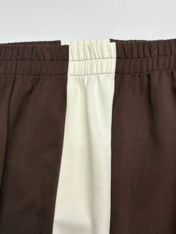 Close-up of casual brown and white jogger pants with elastic waistband, suitable for comfortable everyday wear.