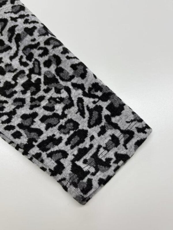 Close-up of leopard print fabric with black and gray pattern, suitable for clothing and accessories.