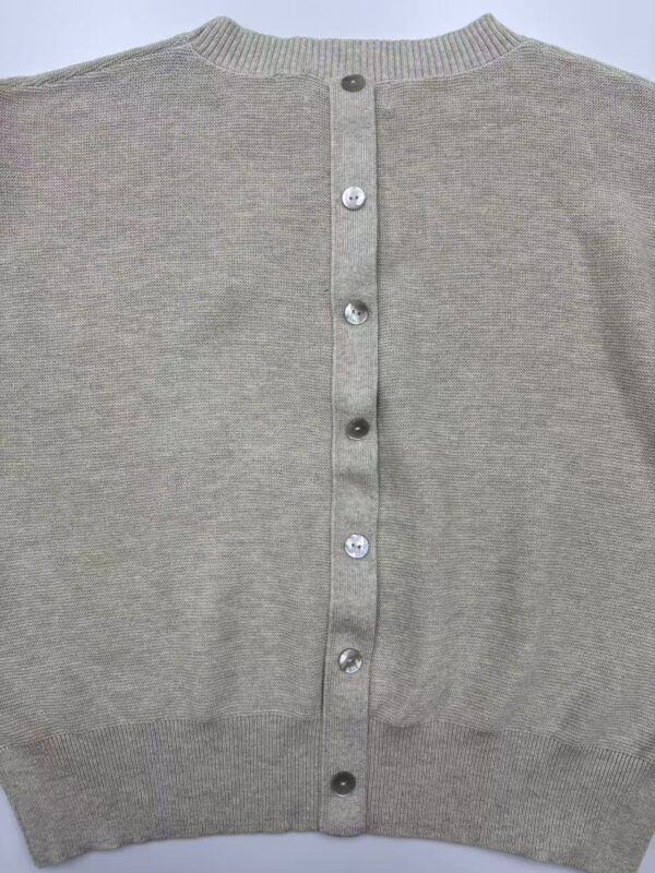 Close-up of a grey women's cardigan with button closure, showcasing soft knit fabric and classic design, perfect for casual or office wear.