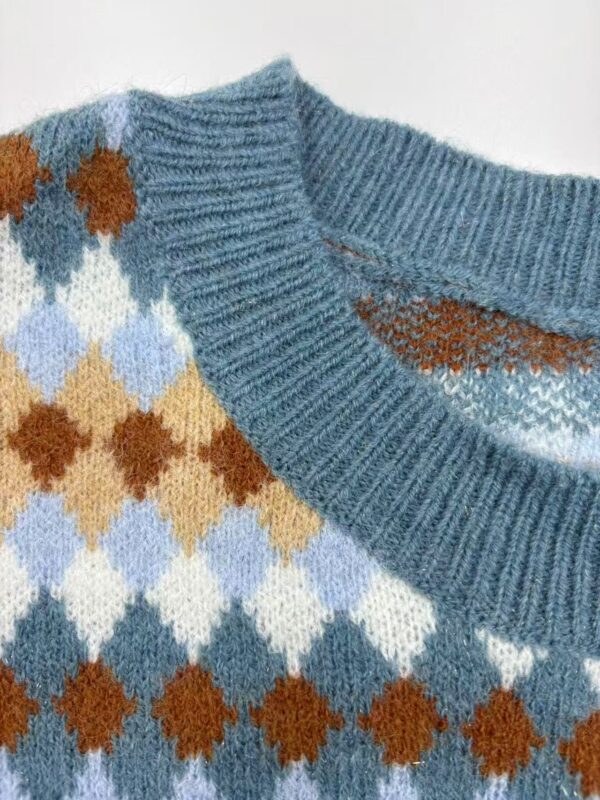Close-up of a cozy argyle sweater featuring blue, brown, white, and beige diamond patterns with a ribbed neckline.