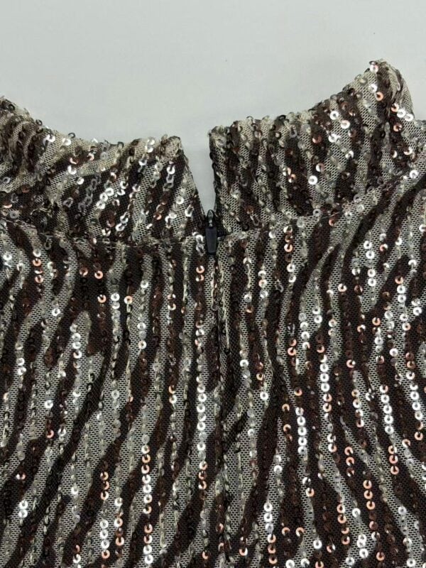 Close-up of a sequin dress with black and silver sequins, showcasing a high neckline and intricate design for stylish evening wear.