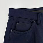 Close-up of navy blue men's dress pants showing waistband, belt loop, and front pocket details, perfect for formal or business attire.