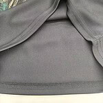 Close-up of a gray sportswear top with seamless design, perfect for activewear and casual wear, displayed on a floral background.
