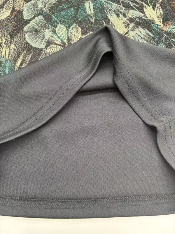 Close-up of a gray sportswear top with seamless design, perfect for activewear and casual wear, displayed on a floral background.