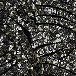 Close-up of black fabric adorned with shiny silver sequins, perfect for glamorous clothing and accessories.