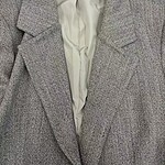Close-up of a stylish women's blazer with a herringbone pattern, suitable for professional and formal occasions.