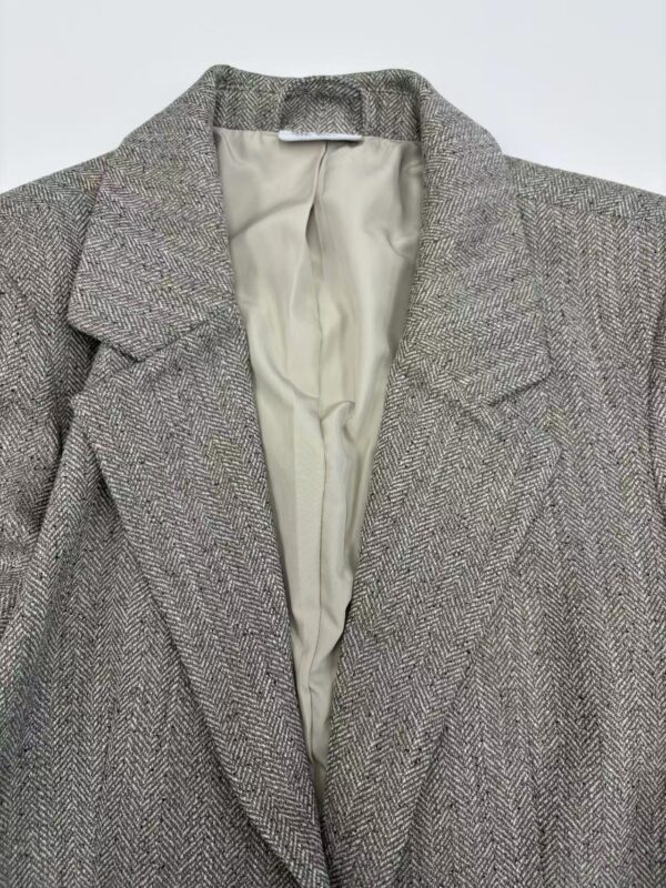 Close-up of a stylish women's blazer with a herringbone pattern, suitable for professional and formal occasions.