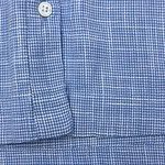 Close-up of a blue micro-check dress shirt with button detail, perfect for formal or business wear.