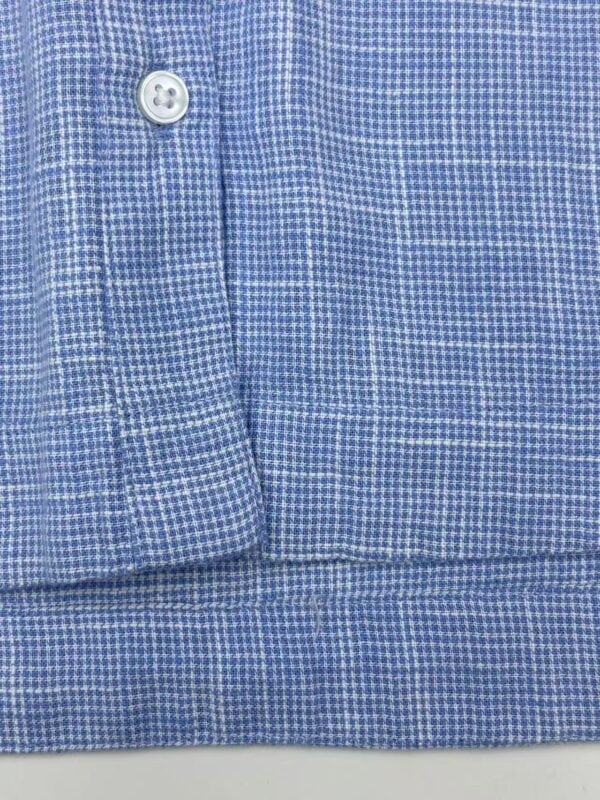 Close-up of a blue micro-check dress shirt with button detail, perfect for formal or business wear.