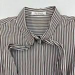 Close-up of a stylish brown and white vertically striped women's shirt with a collar, perfect for casual or office wear.