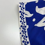 Close-up of a blue fabric with white abstract and decorative patterns, showcasing detailed design and craftsmanship.