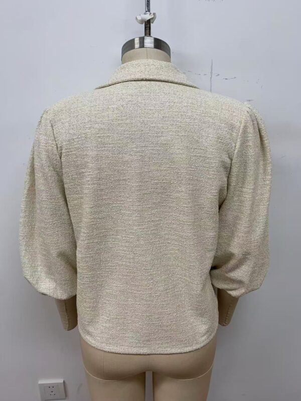 Beige women's blazer with puffed sleeves, tailored fit, and textured fabric, ideal for professional and casual occasions.