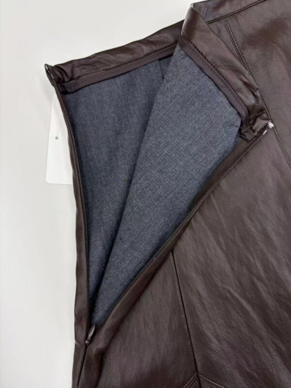 Close-up of a brown leather jacket with a gray wool lining, showcasing quality craftsmanship and fashionable design.
