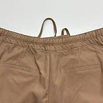 Close-up of beige casual women's pants with elastic waistband and back pockets, suitable for everyday wear and comfortable fashion.