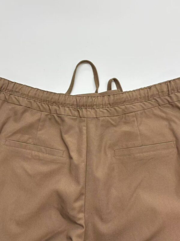 Close-up of beige casual women's pants with elastic waistband and back pockets, suitable for everyday wear and comfortable fashion.