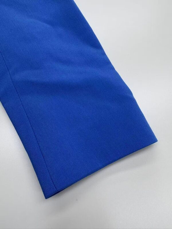 Close-up of a vibrant blue fabric sleeve with clean stitching and smooth texture, ideal for fashion or clothing design.