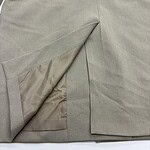 Close-up of a beige women's skirt showing fabric texture and slit detail, perfect for fashion and style enthusiasts.