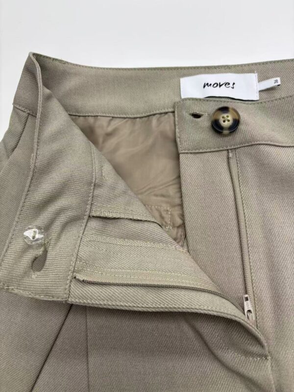 Close-up of beige women's trousers with button and zipper closure, showcasing high-quality fabric and tailored fit, ideal for stylish office wear or casual outings.
