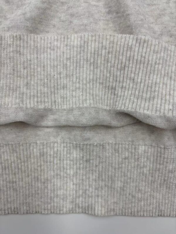 Close-up image of grey ribbed fabric, showcasing the texture and pattern of the material, ideal for fashion and clothing design.