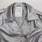 Stylish silver leather jacket with zipper and shoulder epaulets, perfect for fashion-forward women. High-quality material and trendy design.