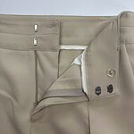Close-up of beige men's formal trousers showing zipper, button, and waistband details, suitable for office wear and professional attire.