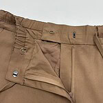 Close-up of men's khaki pants showing zipper, button, and waistband details, suitable for casual or semi-formal wear.