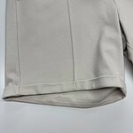 Close-up of a beige women's coat showcasing smooth fabric and tailored design, perfect for stylish winter or fall outfits.