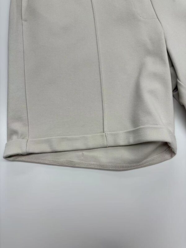 Close-up of a beige women's coat showcasing smooth fabric and tailored design, perfect for stylish winter or fall outfits.