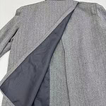 Close-up of a men's grey wool blazer with a smooth lining, tailored for a sophisticated look, perfect for business or formal occasions.