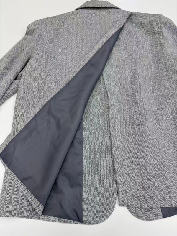 Close-up of a men's grey wool blazer with a smooth lining, tailored for a sophisticated look, perfect for business or formal occasions.
