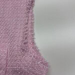 Close-up of pink textured fabric with frayed edge, showcasing detailed weave and soft appearance.