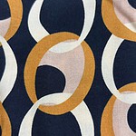 Close-up of fabric with a colorful chain link pattern featuring navy, white, beige, and mustard yellow links, ideal for fashion and textile design.