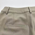 Close-up of khaki dress pants showing waistband and back pocket, suitable for formal or business wear.