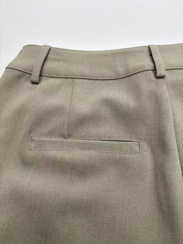 Close-up of khaki dress pants showing waistband and back pocket, suitable for formal or business wear.