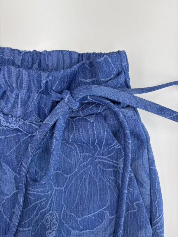 Close-up of blue lounge pants with floral pattern and adjustable drawstring waist, perfect for casual wear and comfort.