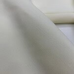 Close-up of smooth, high-quality white fabric suitable for fashion and apparel projects.