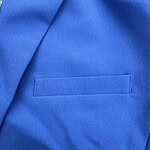 Close-up of a vibrant blue suit fabric with a welt pocket, showcasing fine texture and quality tailoring for men's fashion.