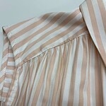 Close-up of a stylish beige and white striped blouse with pleated details, perfect for casual or office wear.