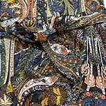 Close-up of vibrant, intricate bohemian fabric with floral and paisley designs in multiple colors.